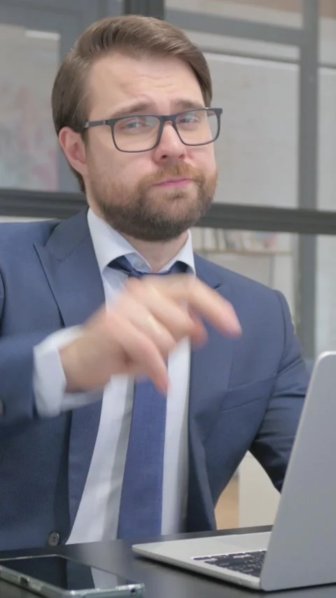 Young Businessman Pointing at Camera while Using Laptop Stock Footage 321108764