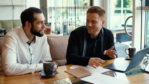 Young businessman showing computer presentation to client sitting at desk Stock-Footage 115357841