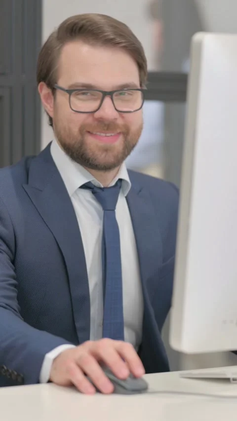Young Businessman Smiling at Camera while Working on Computer Stock Footage 321107157