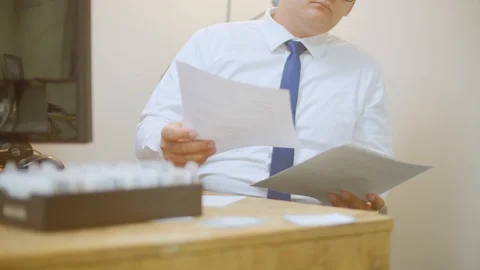 Young Businessman Sorts Through Papers at Desk Stock Footage