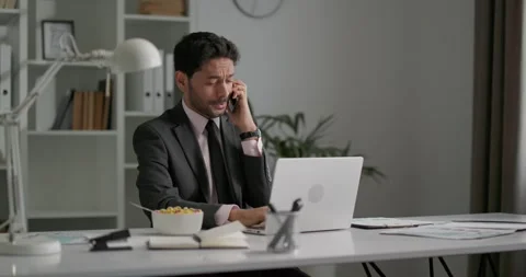 Young businessman speaking on smartphone while sitting at office. Stock Footage 248966530