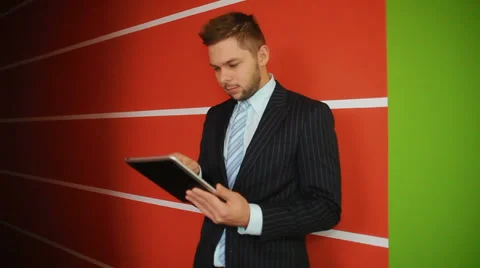 Young businessman with a tablet computer is engaged in business Stock Footage 30900825