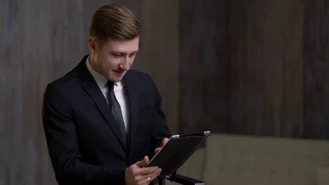 Young businessman with a tablet computer is engaged in business. A man is in a Stock Footage 71406443