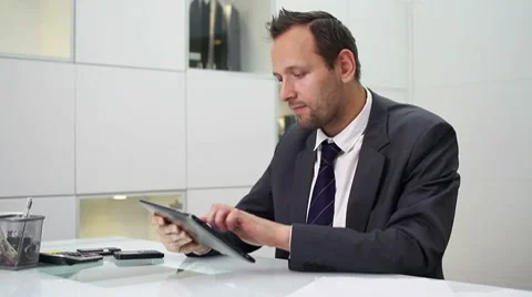Young businessman with tablet computer in modern office HD Video stock 10744845