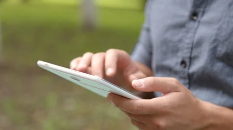 Young businessman with tablet computer sitting on bench in the park Stock Footage 67880891
