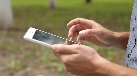 Young businessman with tablet computer sitting on bench in the park Stock Footage 67880968