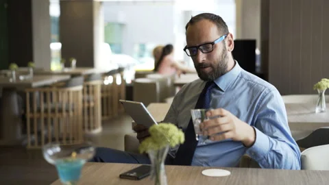 Young businessman with tablet computer sitting in cafe Stock Footage 133037923