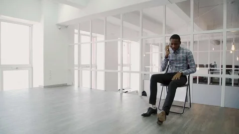 Young businessman talking on phone while sitting in modern office. Stock Footage 82736706