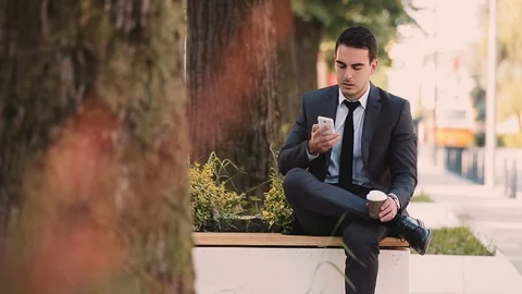 Young Businessman Talking At Phone While Drinking Coffee To Go Stock Footage 87405351