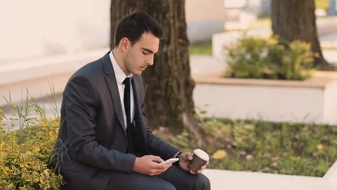 Young Businessman Talking At Phone While Drinking Coffee To Go Stock Footage 87407599