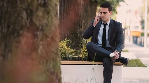 Young Businessman Talking At Phone While Drinking Coffee To Go Video stock 87452865