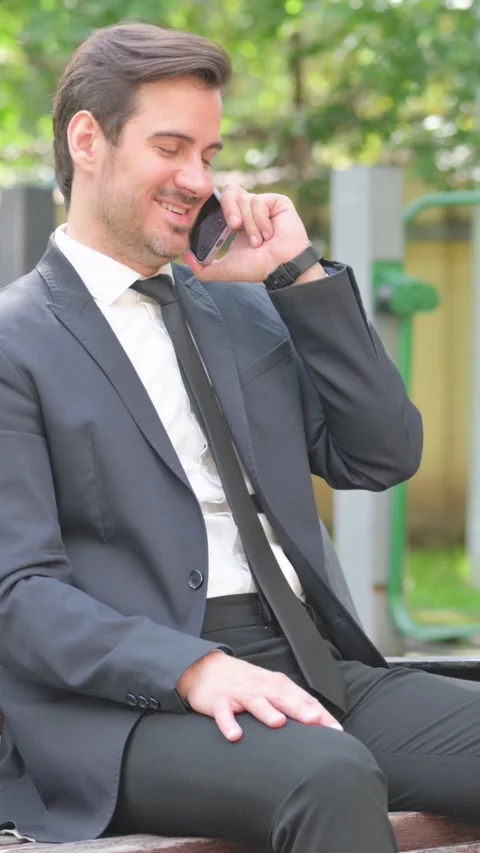 Young Businessman Talking on phone while Sitting on Bench Video stock 319971895