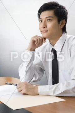 Young businessman thinking at a desk Stock Photos