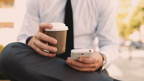 Young Businessman Typing On Phone While Drinking Coffee To Go Video stock 87408408
