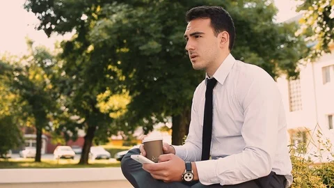 Young Businessman Typing On Phone While Drinking Coffee To Go Stock Footage 87409122