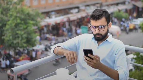 A young businessman using a cellphone while drinking coffee Stock Footage 94131577