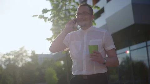 Young businessman using cellphone while walking near office. Stock Footage 156188923