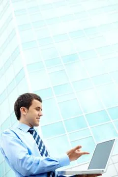 Young businessman using computer by office building 스톡 사진