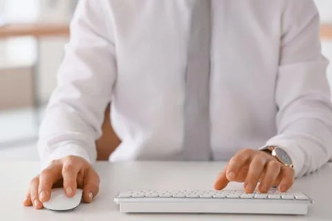 Young businessman using computer to search online at desk in office, closeup Stock Photos