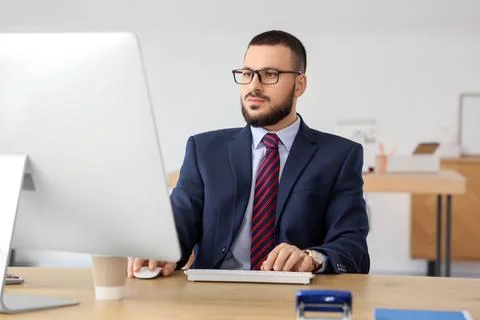 Young businessman using computer to search online in office Stock Photos