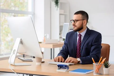 Young businessman using computer to search online in office Stock Photos