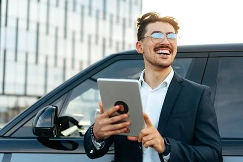 Young businessman using digital tablet while standing outdoors Stock Photos