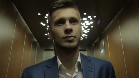 Young businessman using elevator Stock Footage 64233311