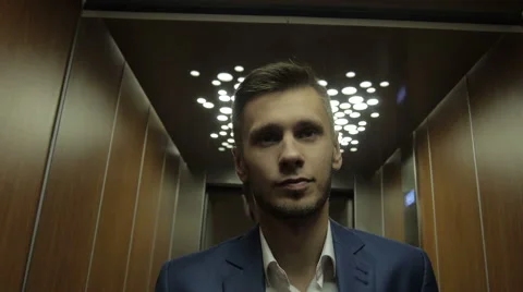 Young businessman using elevator Stock Footage 64233324