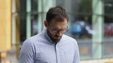 Young businessman using his phone in the street Stock Footage 64112396