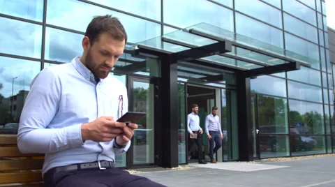 Young businessman using his tablet in the street Stock Footage 64161503