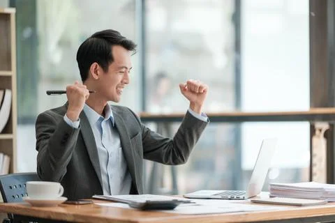 Young Businessman Using Laptop Computer in Modern Office. Manager Thinks About Stock Photos