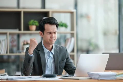 Young Businessman Using Laptop Computer in Modern Office. Manager Thinks About Stock Photos