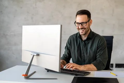 Young businessman using laptop computer in office. Manager thinks about Stock Photos