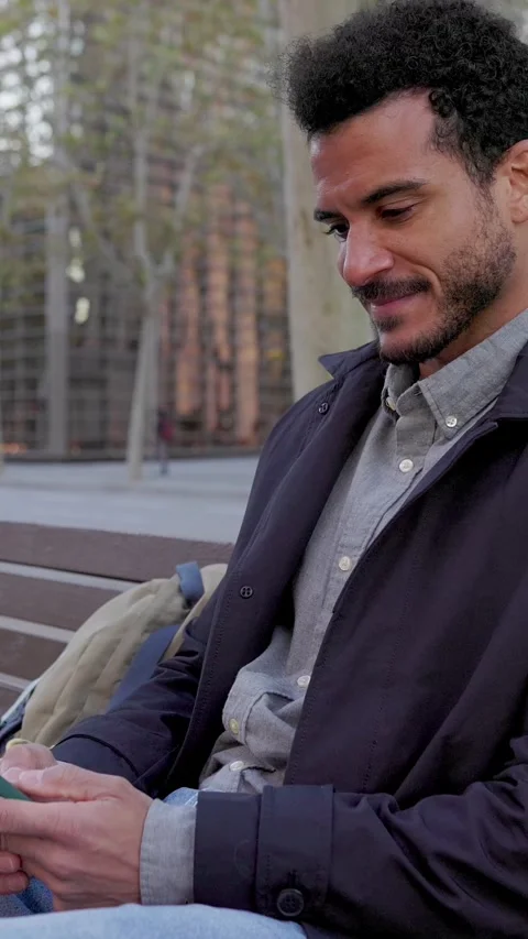 Young businessman using a smartphone on a bench in the city Stock Footage 345248940