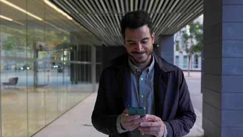 Young businessman using a smartphone while walking outdoor Stock Footage 345096263
