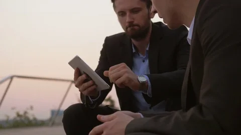 Young businessman using a tablet and sharing information. Stockbeeldmateriaal 76050201