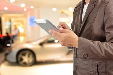 Young BusinessMan using Tablet device with Modern Sportcar Stock Photos