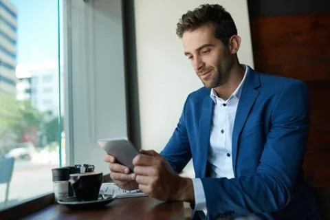 Young businessman using a tablet over coffee in a cafe Stock Photos