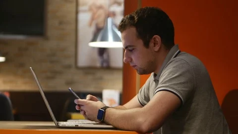 Young businessman working on computer in cafe. 4k. Stock Footage 79853033