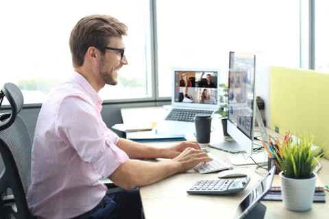 Young businessman working on computer, doing video conference with collegues Stock Photos
