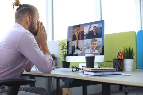Young businessman working on computer, doing video conference with collegues Stock Photos