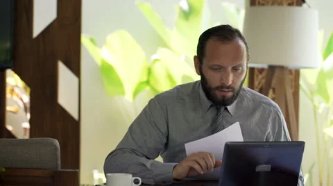 Young businessman working with documents and laptop by desk at office Stock Footage 64270475