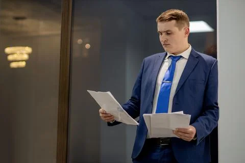 Young businessman working with documents looking through papers in folder, si Stock Photos