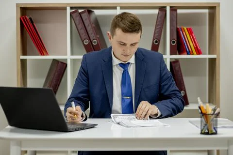 Young businessman working with documents looking through papers in folder, si Stock Photos