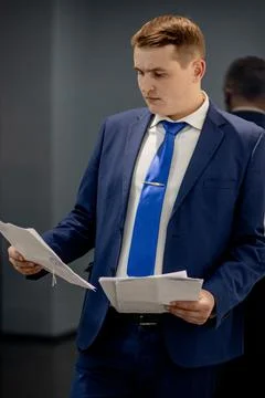 Young businessman working with documents looking through papers in folder, si Stock Photos