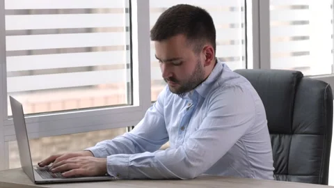 Young businessman working on laptop computer at home office Stock Footage 194119600