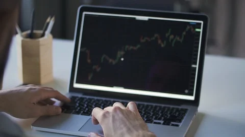Young businessman working is with laptop while sitting at table in modern office Stock Footage 126702555