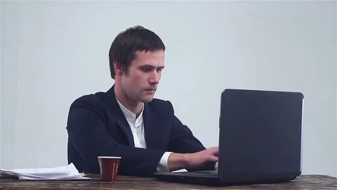 Young businessman working on a notebook,. Drinks cofee. Stock-Footage 73004609