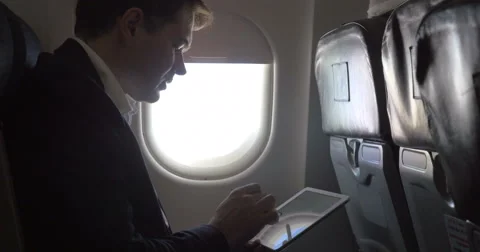 Young businessman working with pad in plane Stock-Footage 51661985