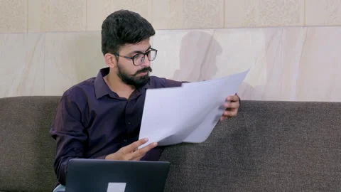 Young businessman working with paper documents and laptop at the home office Video stock 158142593